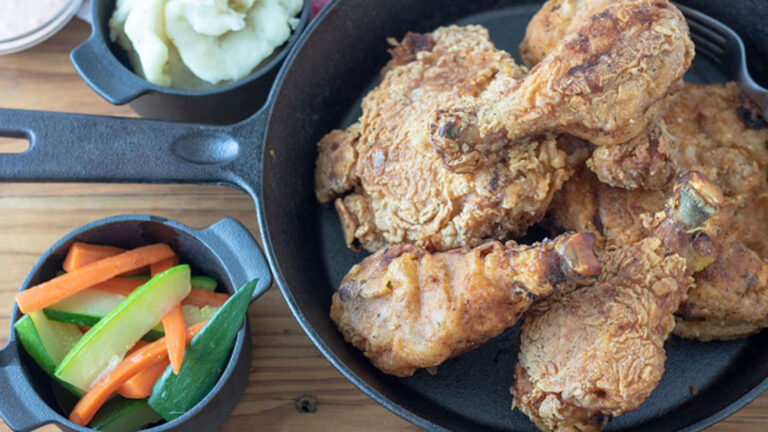 Crispy fried chicken in a cast iron frying pan.