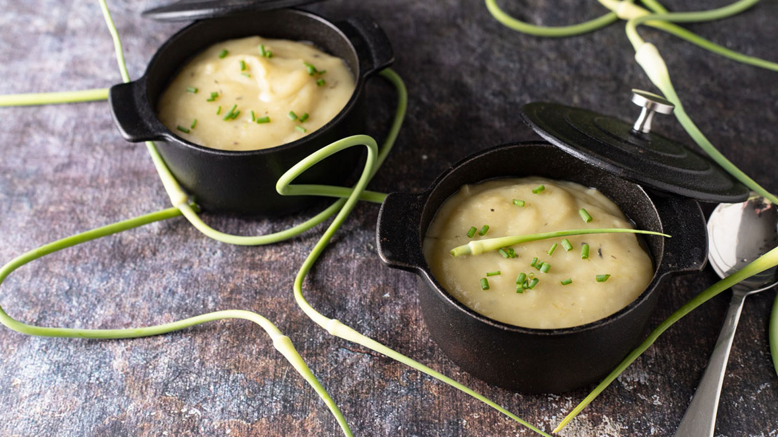 Two mini cast iron Dutch ovens with potato soup.