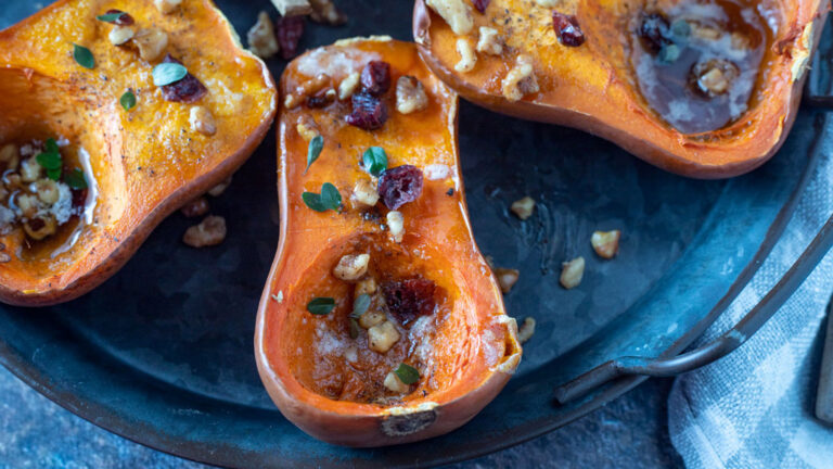 Roasted honeynut squash garnished with dried cranberries and thyme.