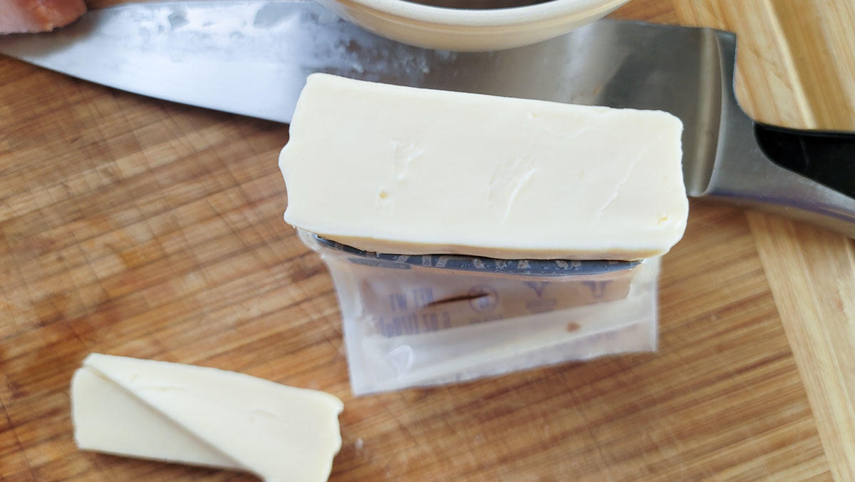 Side view of a rectangular block of cheese.