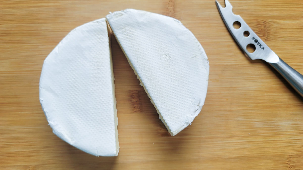 Wheel of brie sliced in half.