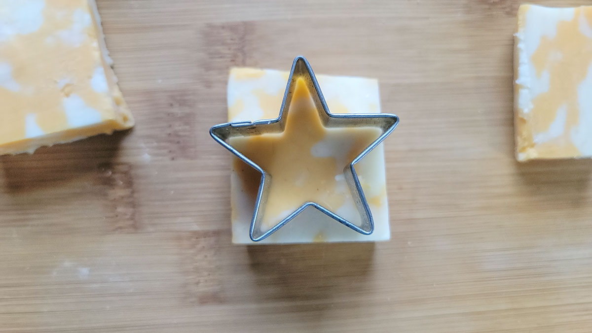 Cutting a star shape out of a piece of cheese.