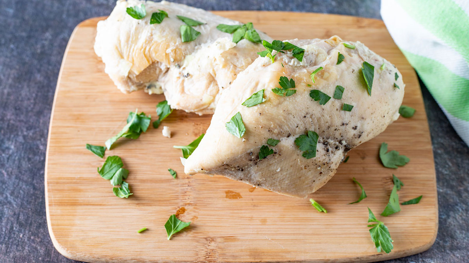 Boneless skinless chicken breasts garnished with chopped parsley.