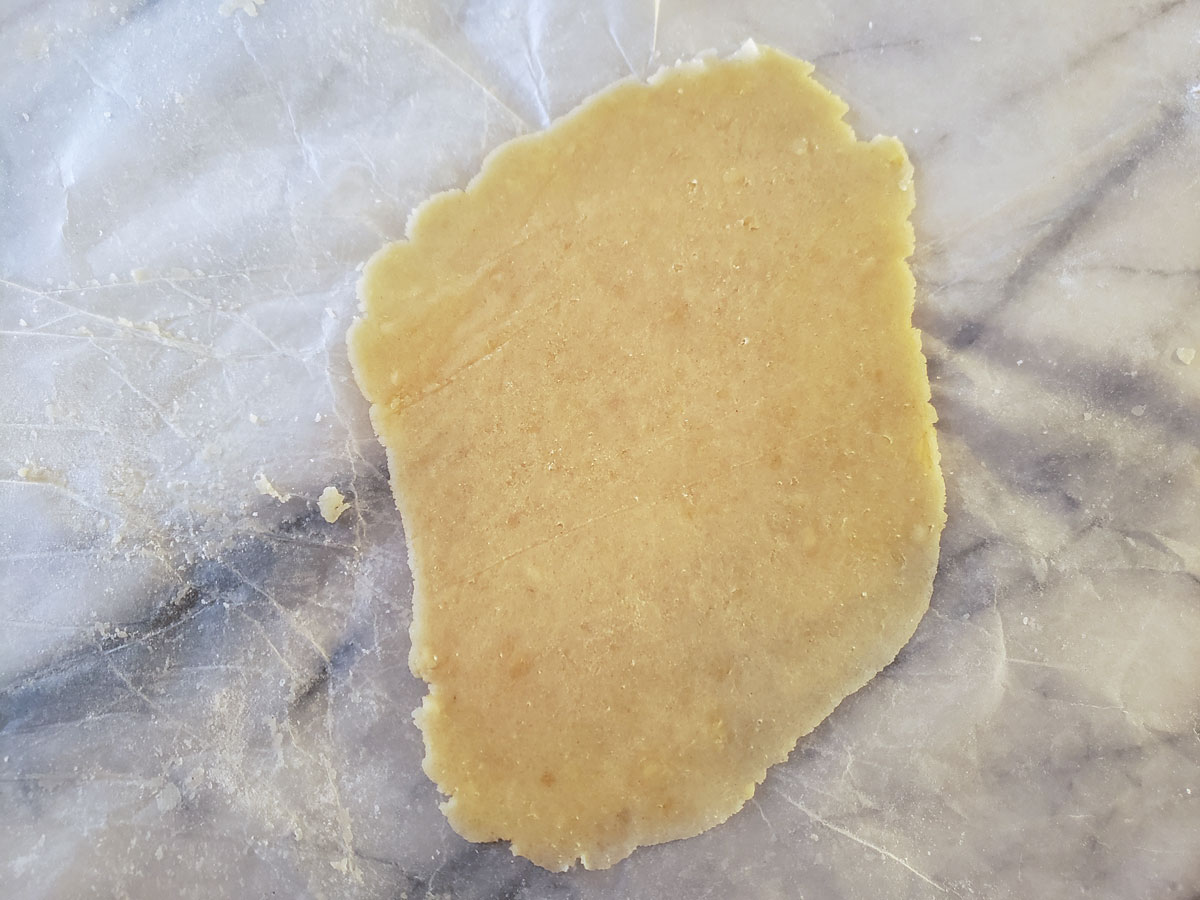 Dough rolled out on a sheet of waxed paper.
