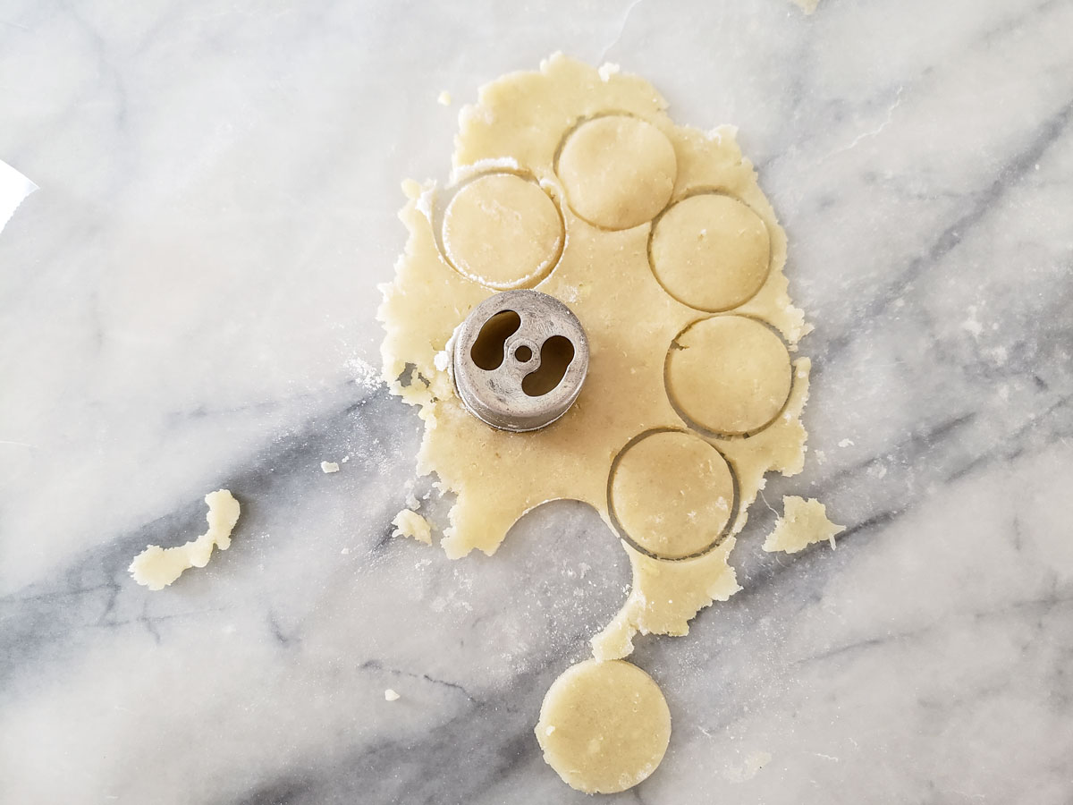 Cutting out small round pieces of dough.