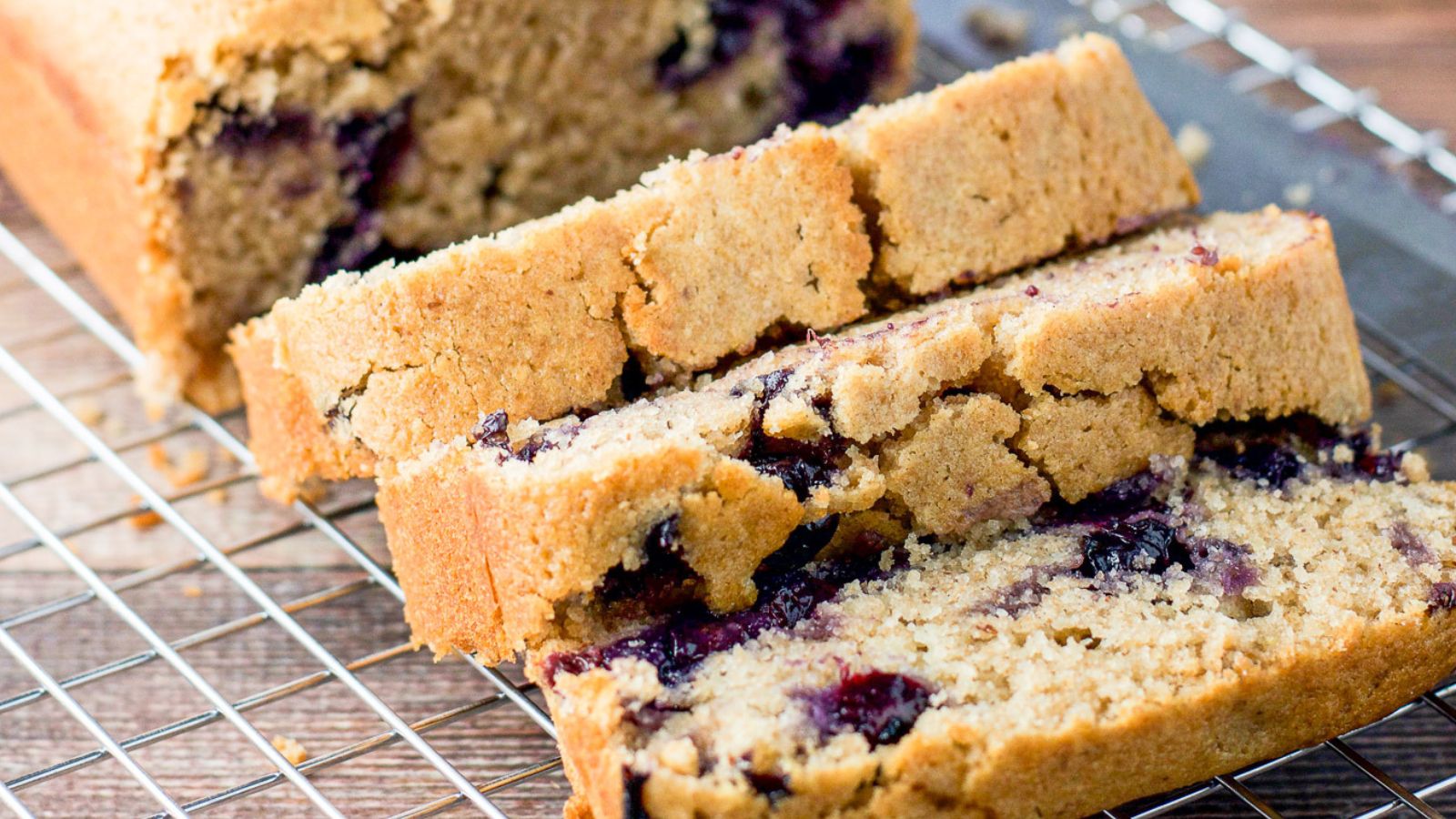 Slices of blueberry bread on a wire rack.