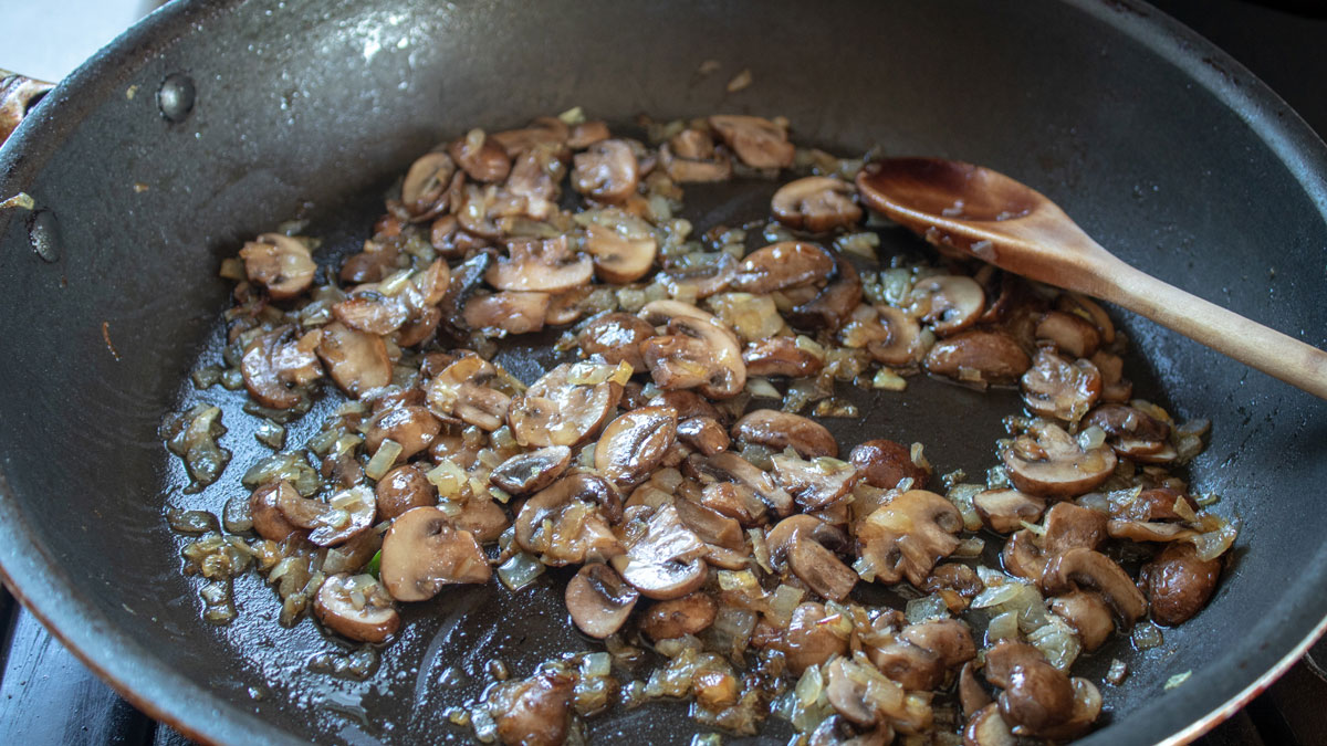 Lightly browned mushrooms in the skillet.