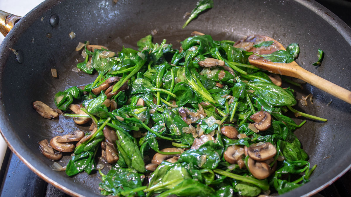 Spinach added to the onions and mushrooms.