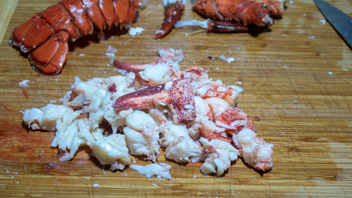 Chopped lobster on a cutting board.