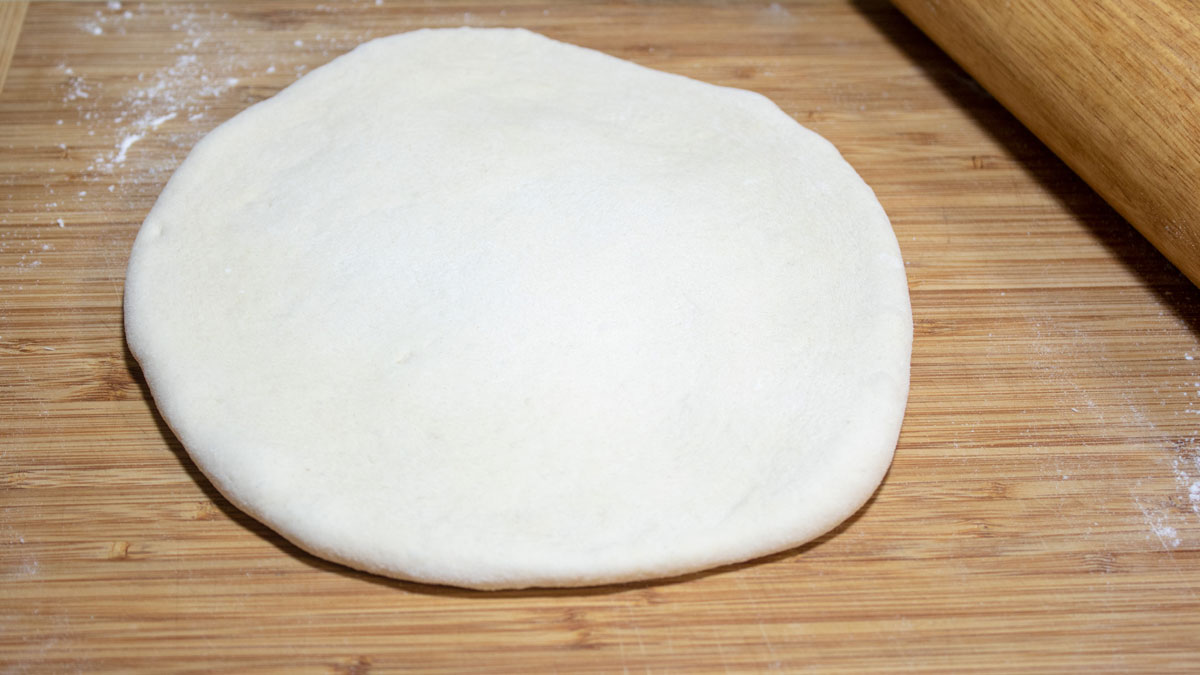 Pizza dough rolled into a circle.