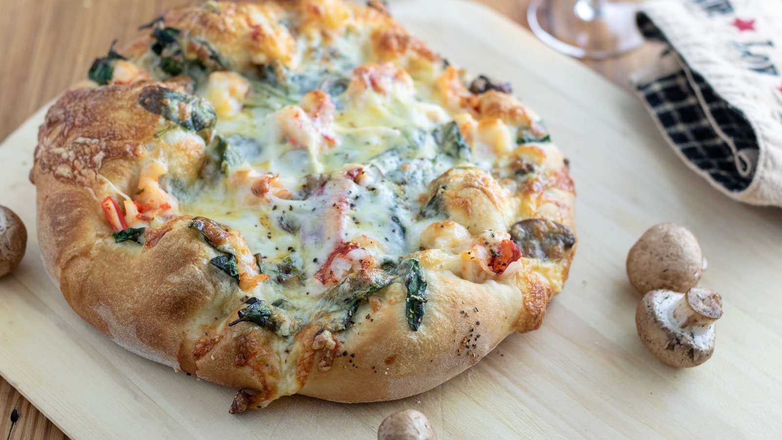 Whole lobster pizza and a peel with mushrooms.