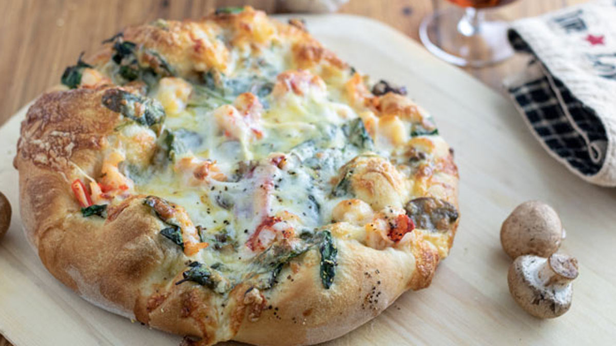 Whole lobster pizza and a peel with mushrooms.