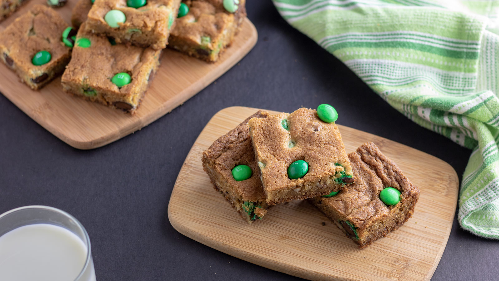 Stack of mint cookie bars on wooden boards.