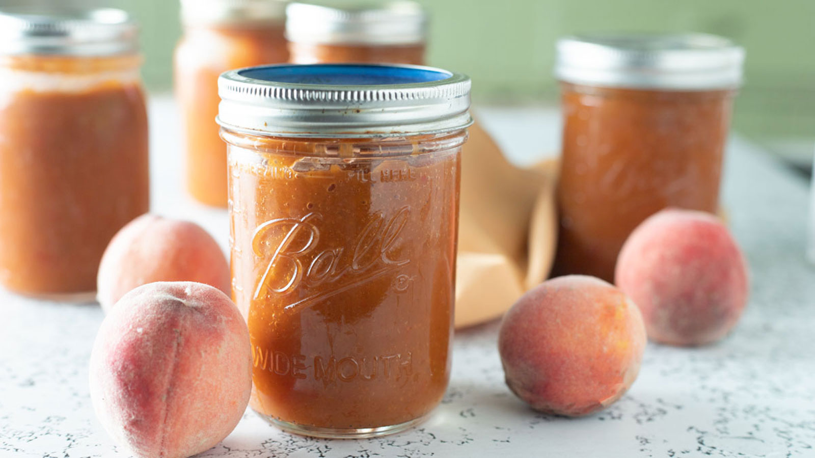 Peach bourbon BBQ sauce with fresh peaches in photo.