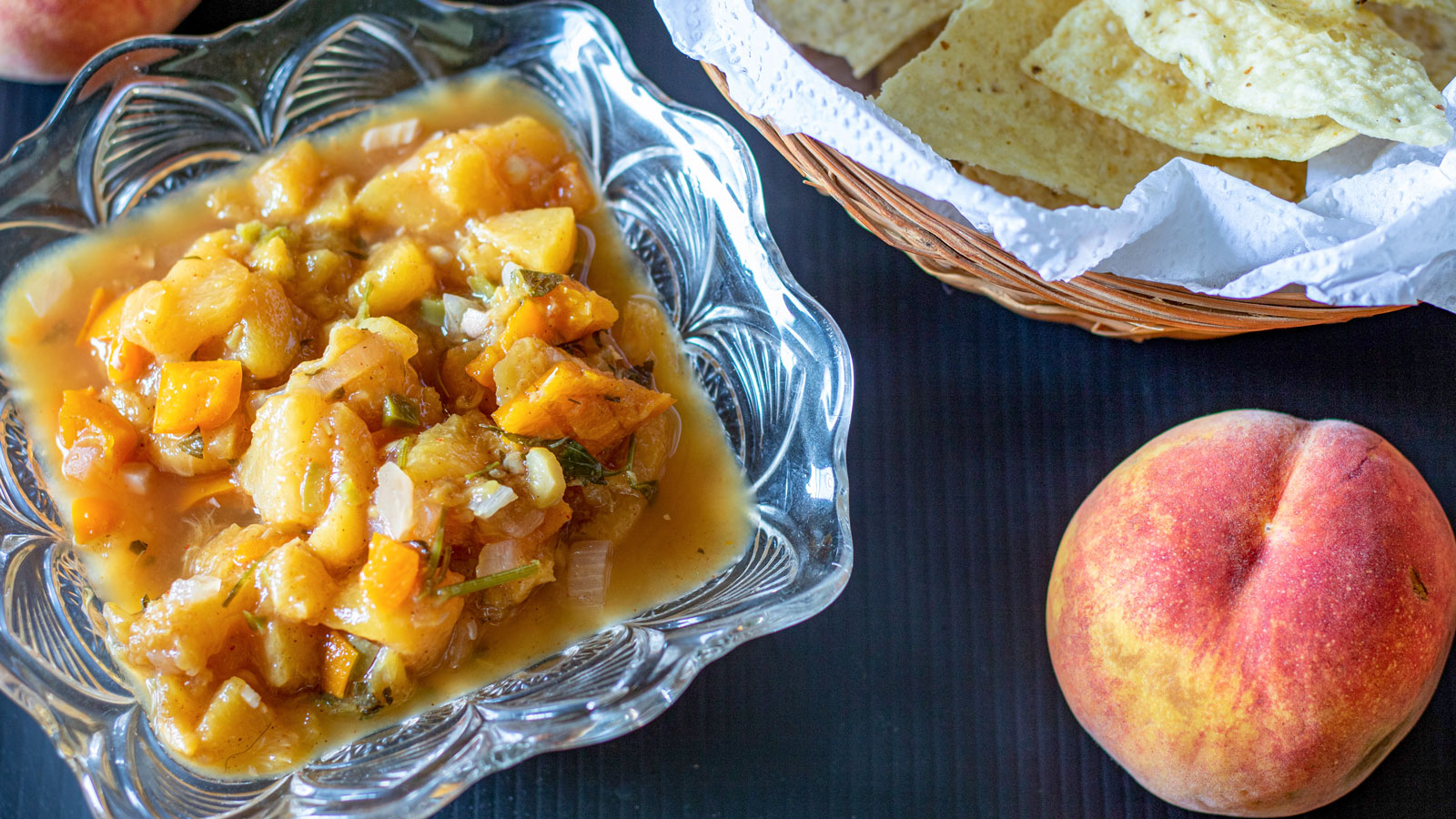 Glass bowl filled with peach salsa.