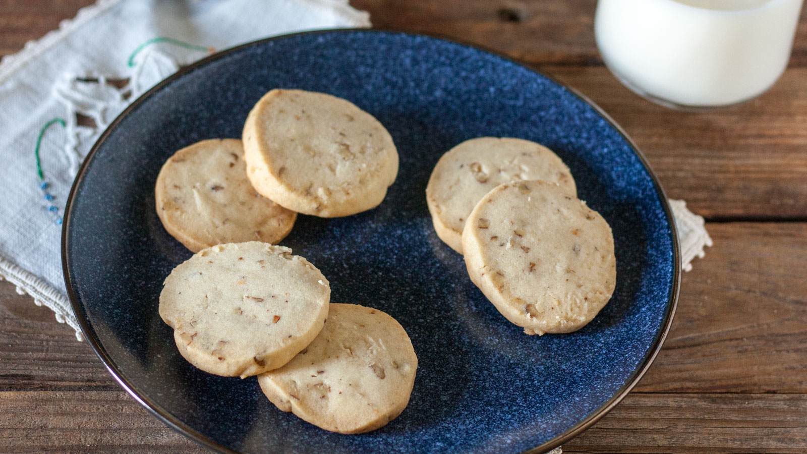 White pecan sandies on a dark blue plate.