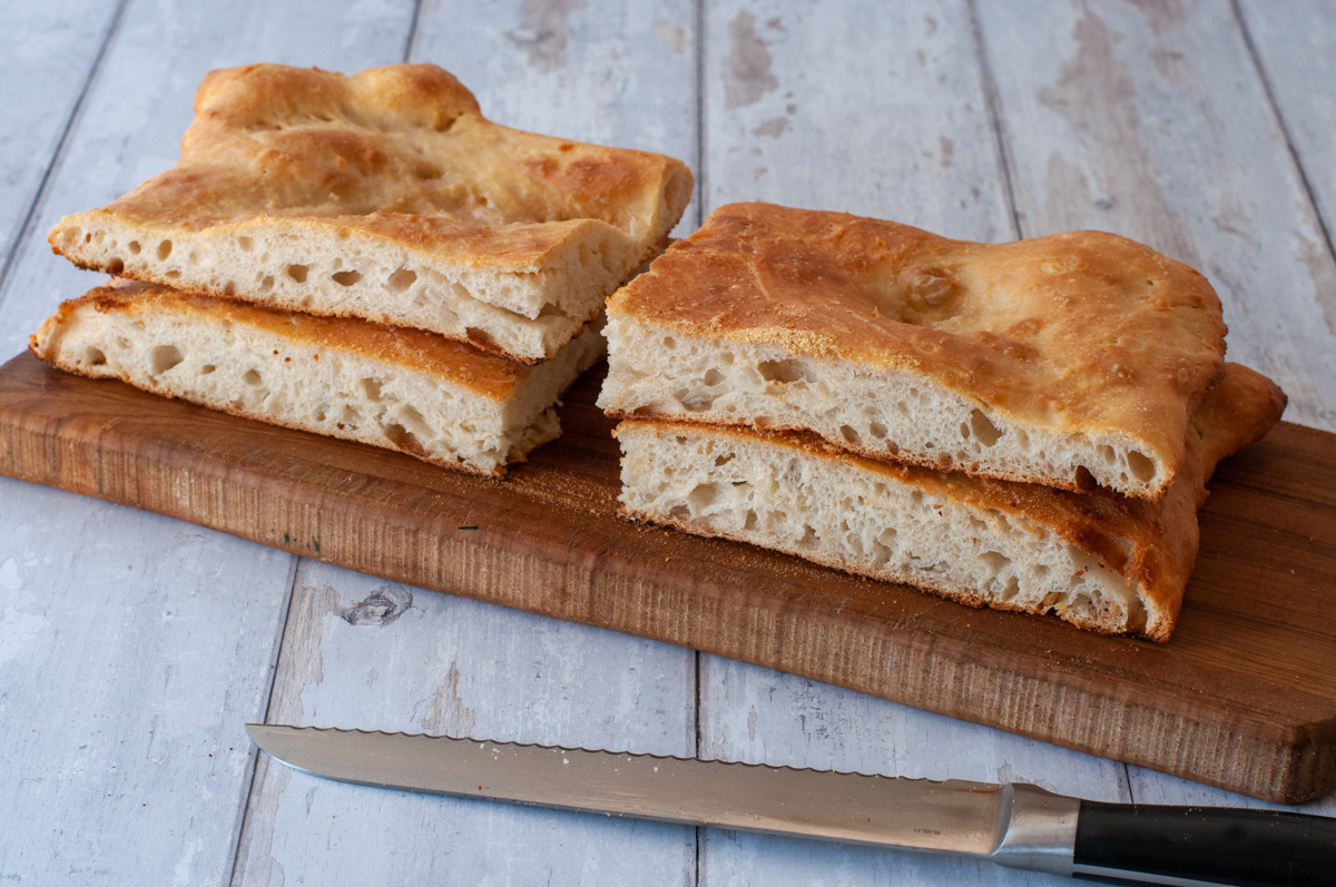 Slices of pizza bianca on a wooden board.
