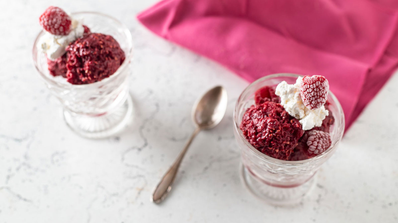 Pink raspberry sorbet in dessert fluted dishes.