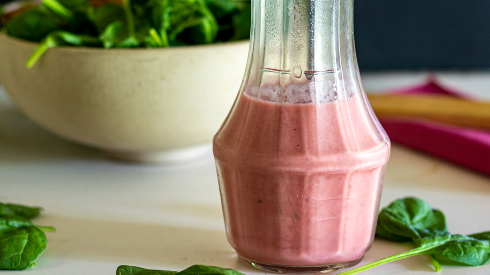 Pink rhubarb vinaigrette in cruet.