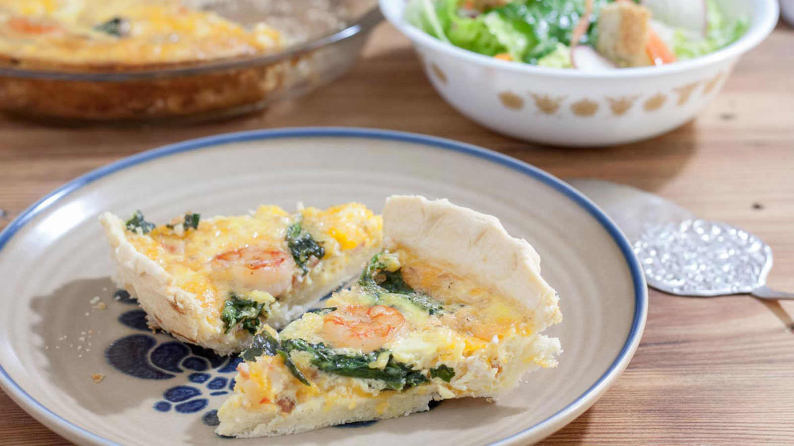 Two slice of shrimp quiche on beige plate.