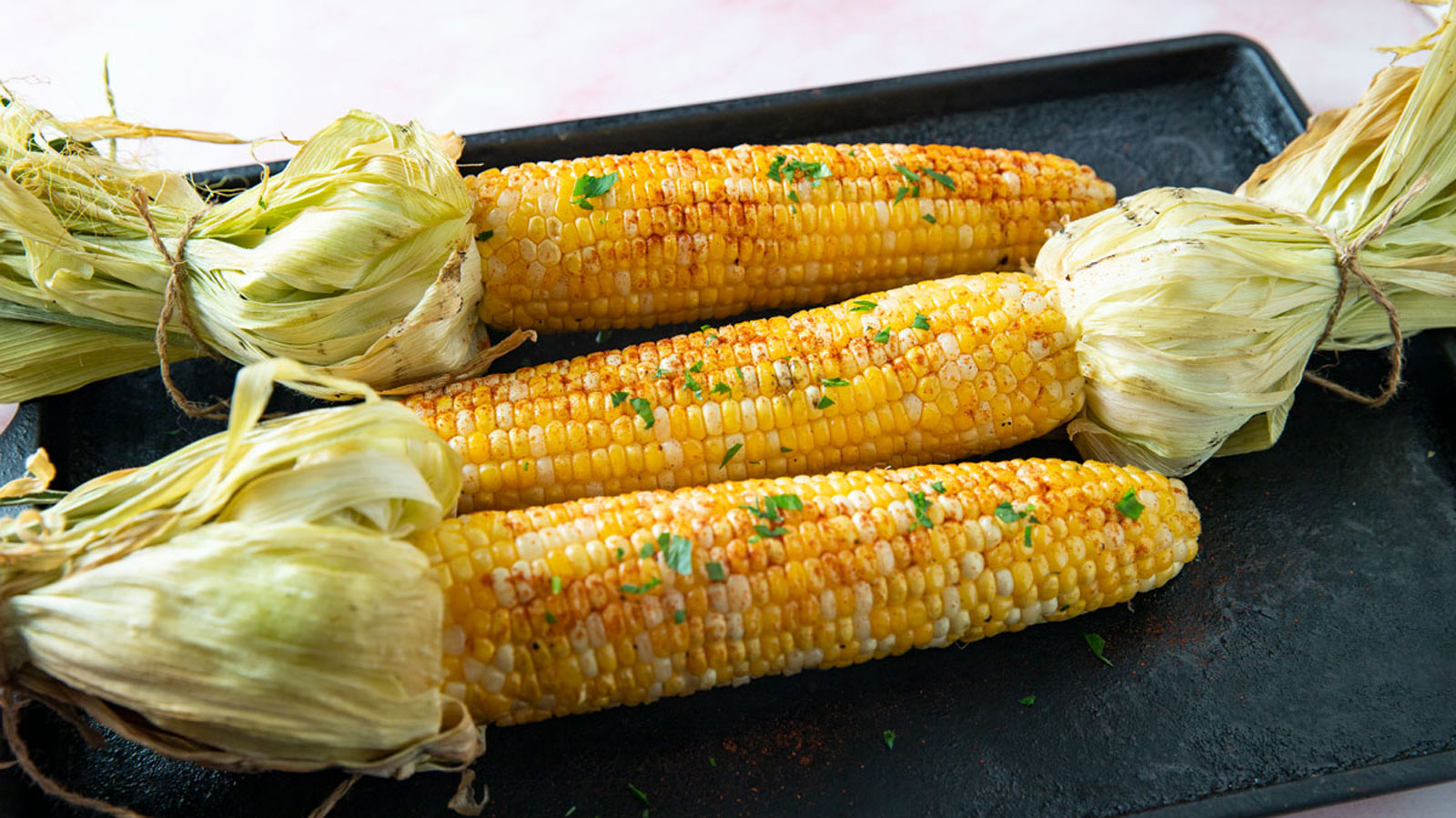 Smoked corn piled on a cast iron pan.