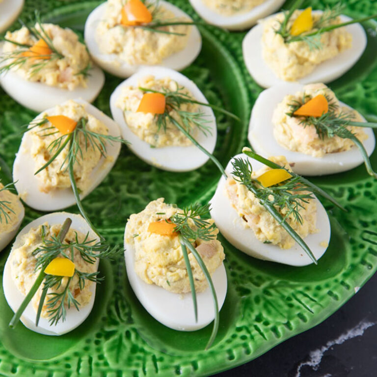 Deviled eggs garnished with fresh dill and chives.