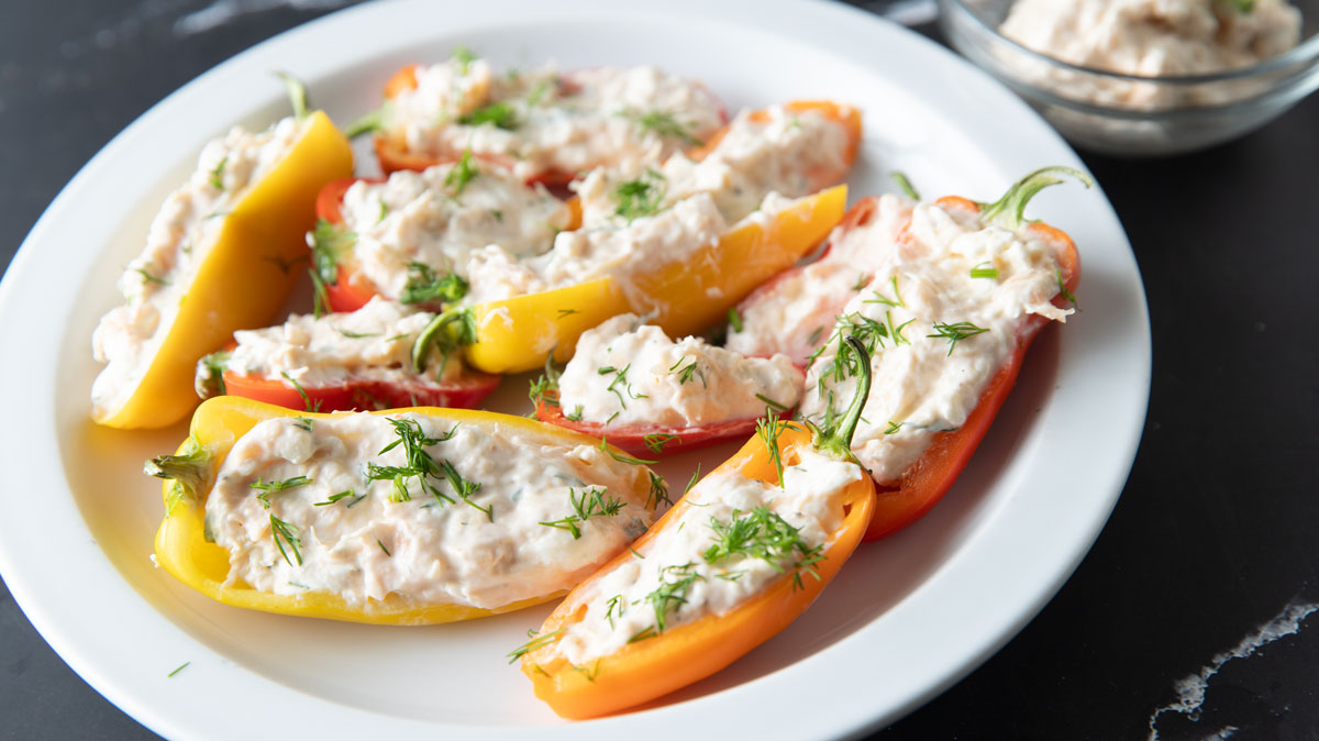 Smoked salmon dip stuffed bell peppers on a white plate.