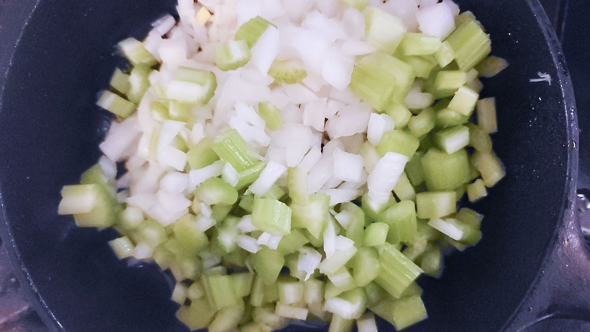 Celery and onion added to cast iron skillet. 