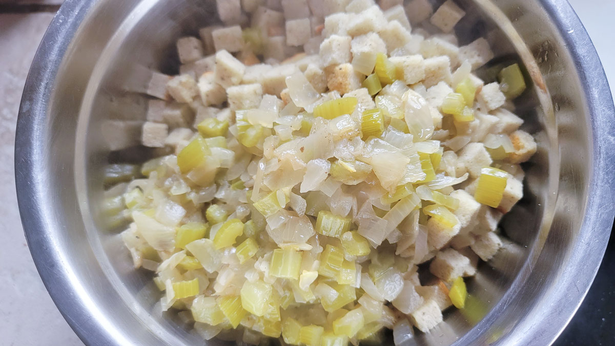 Vegetables added to the bread crumbs in a large bowl.