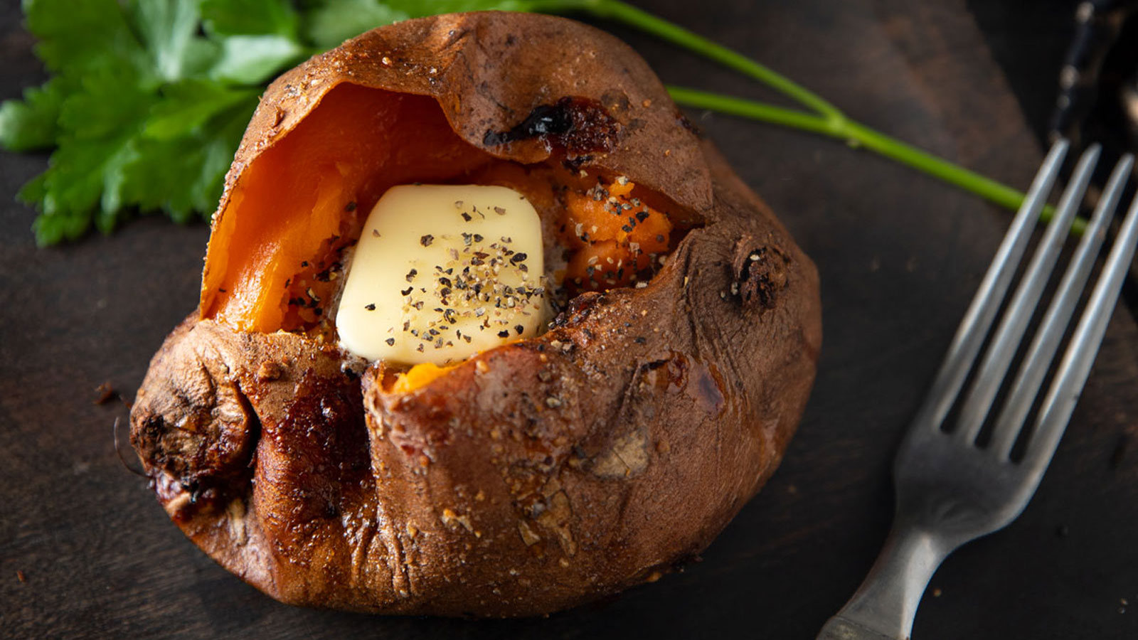 Sweet potato with parsley on a wooden plate.