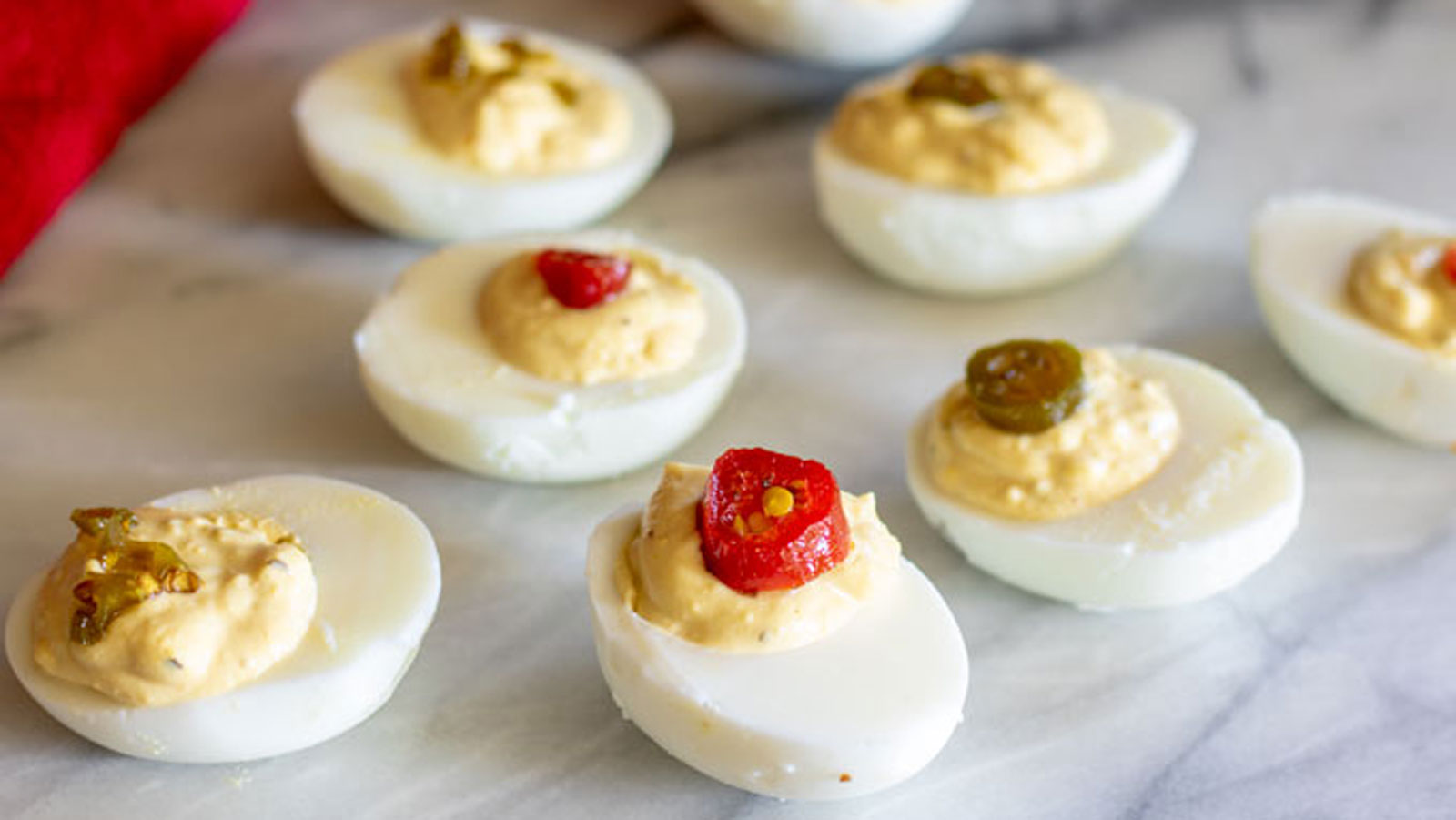 Deviled eggs topped with candied jalapenos.