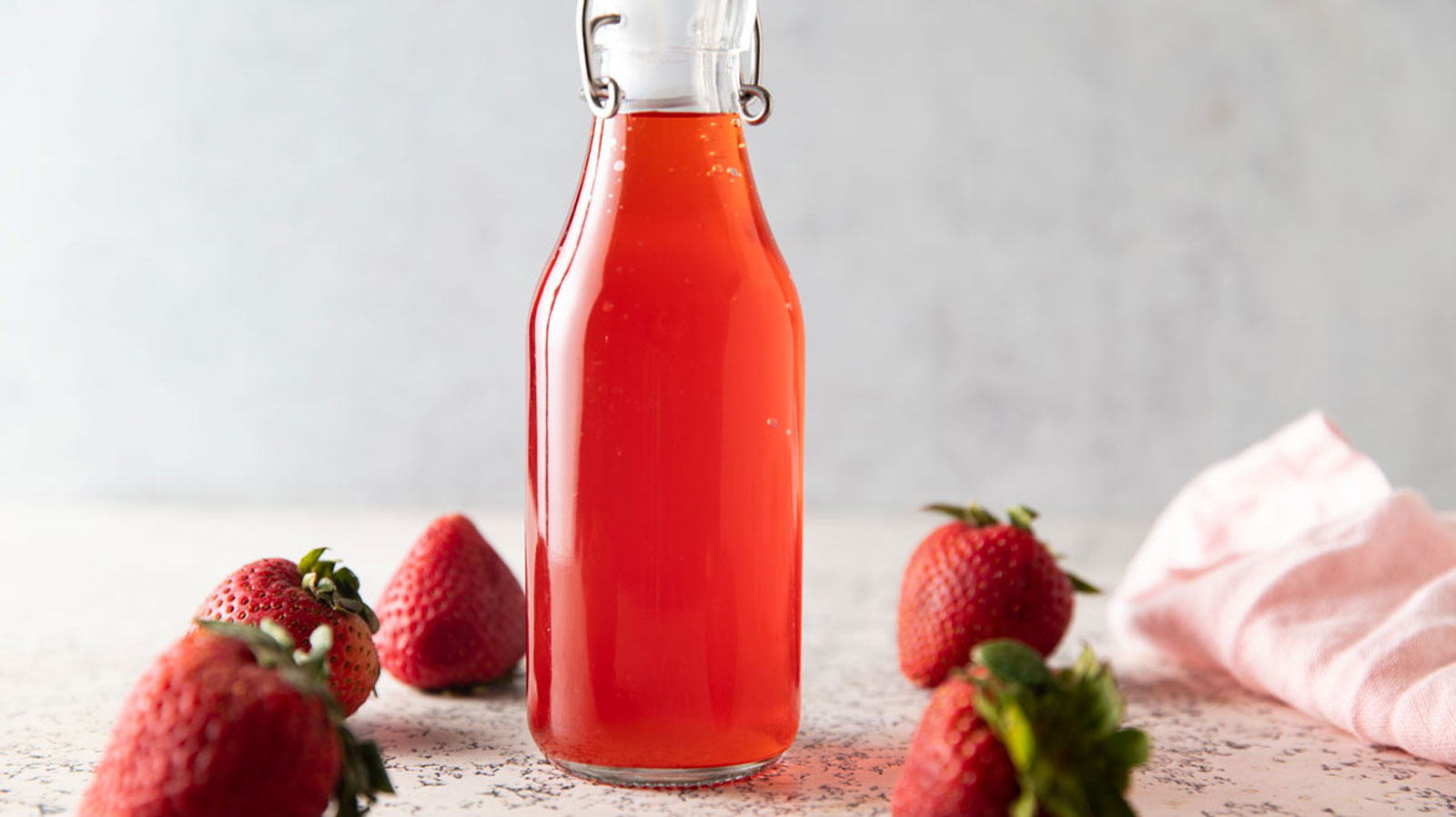 A bottle full of strawberry vinegar.