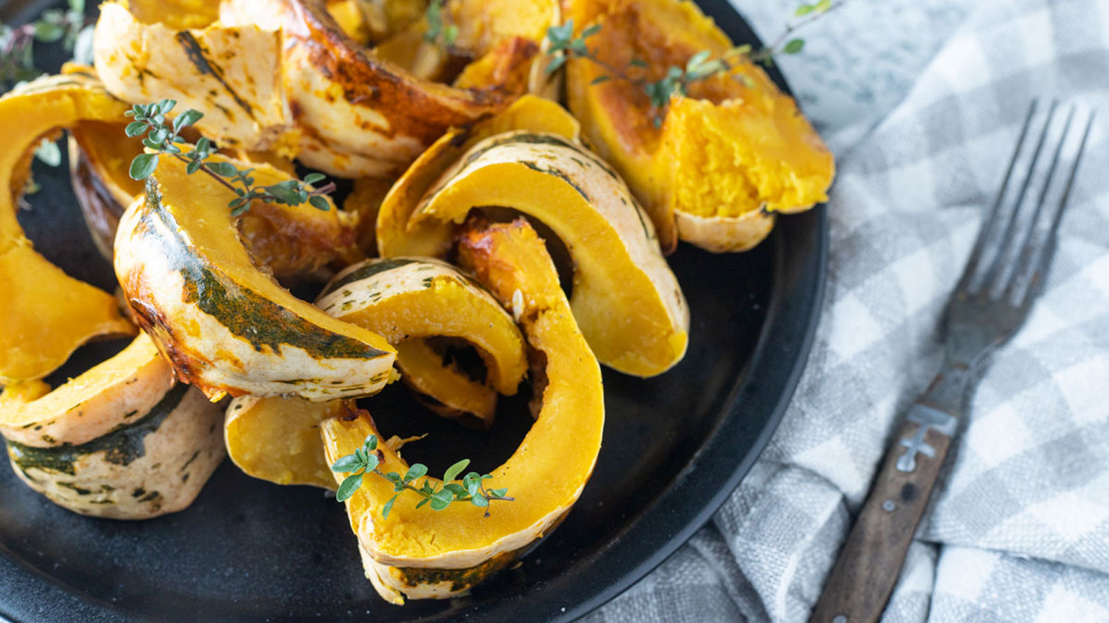 Sliced squash on black plate.