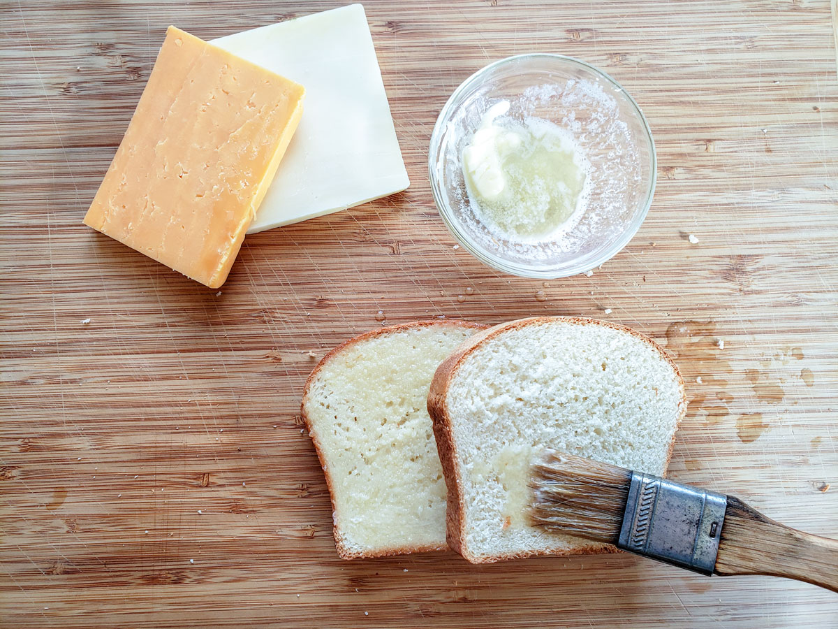 Brushing the bread with melted butter.