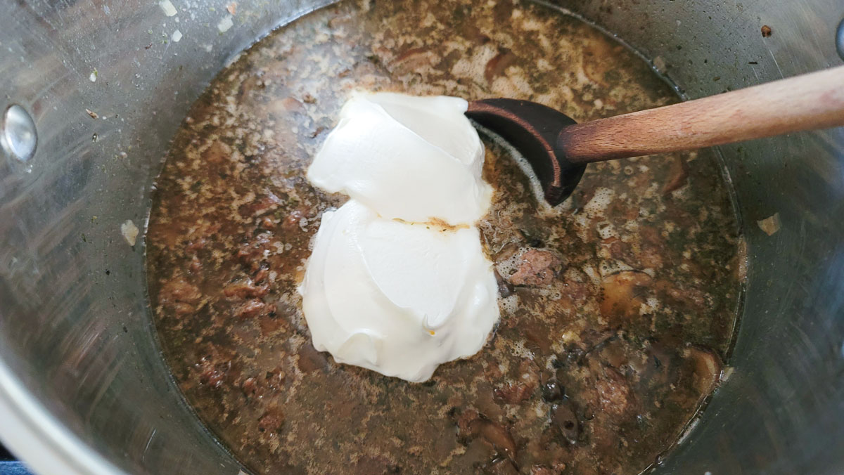 Adding sour cream to the stew.