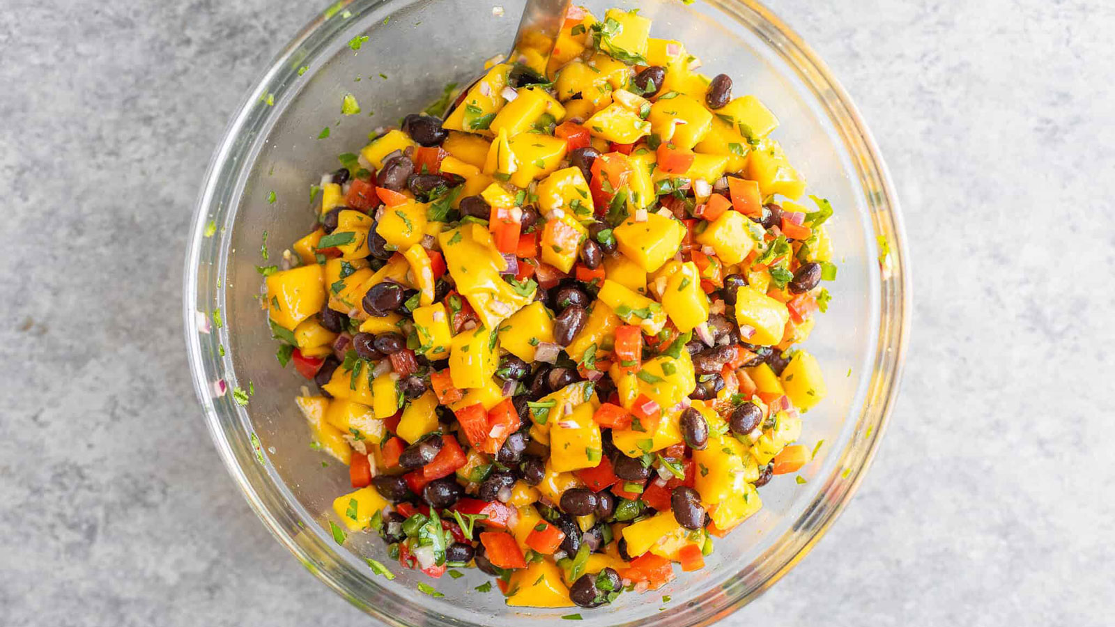 Clear bowl filled with mango salsa.