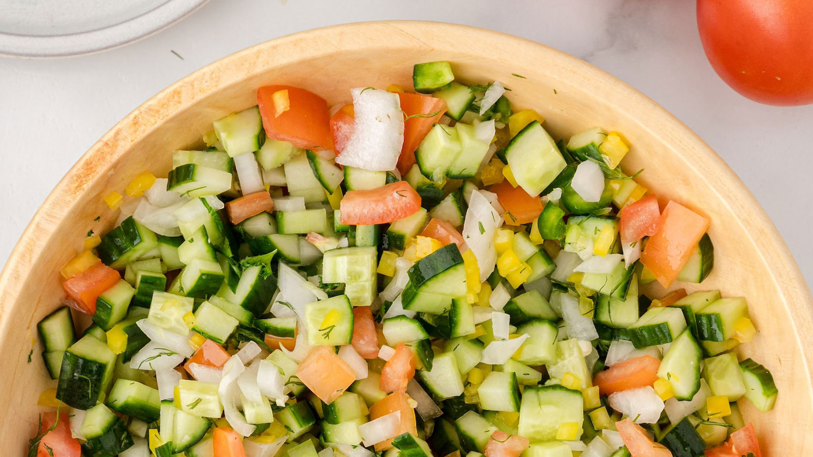 Bowl of cucumber salsa on a white background