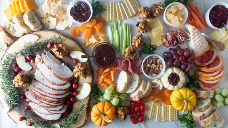 Epic Fall Charcuterie Board with cheeses, turkey, bread, cranberries.