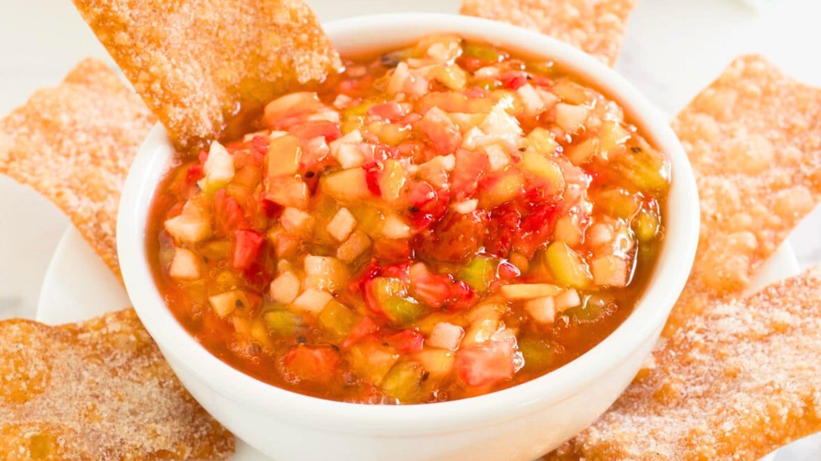 Fruit salsa in a white bowl with chips.