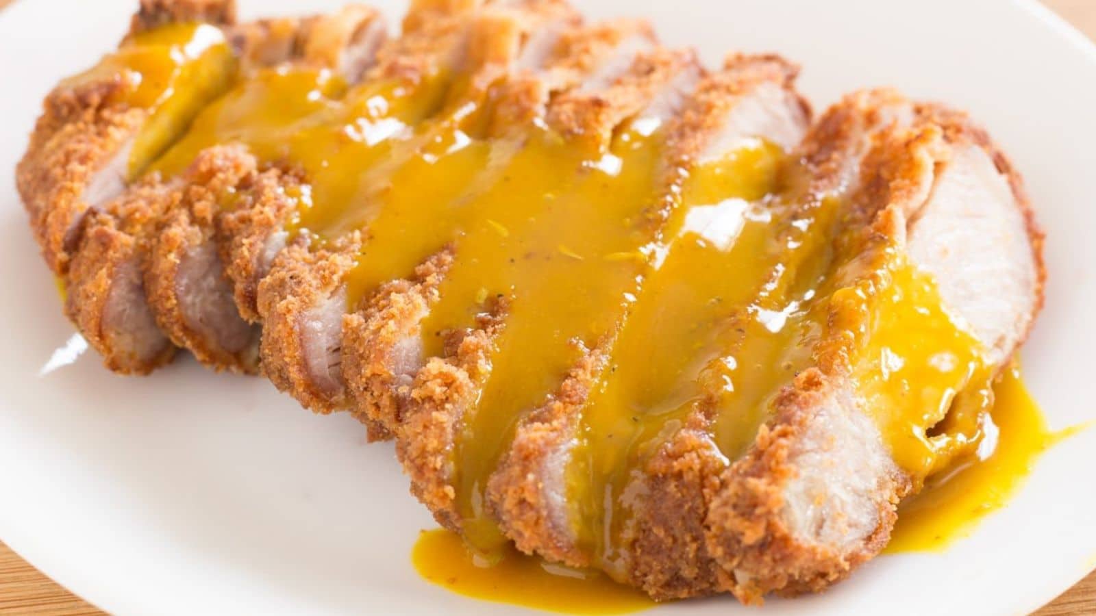 Gravy poured over sliced, breaded pork chops.