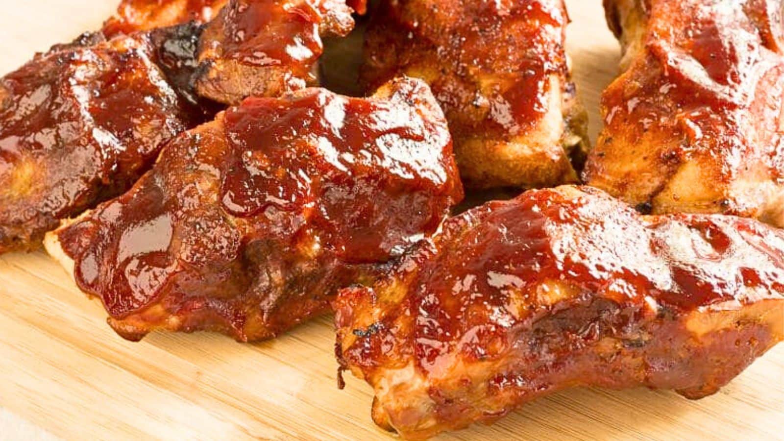 Saucy BBQ ribs on a board.