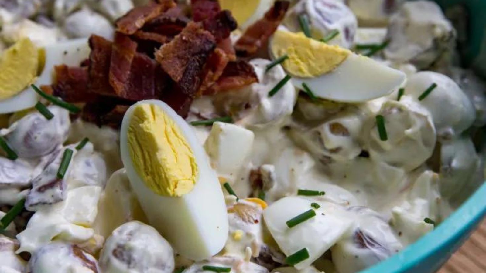 Close up of potato salad with bacon and eggs.