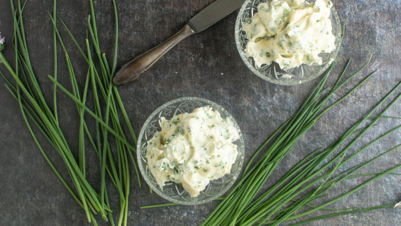 Two small ramekins with chive butter.