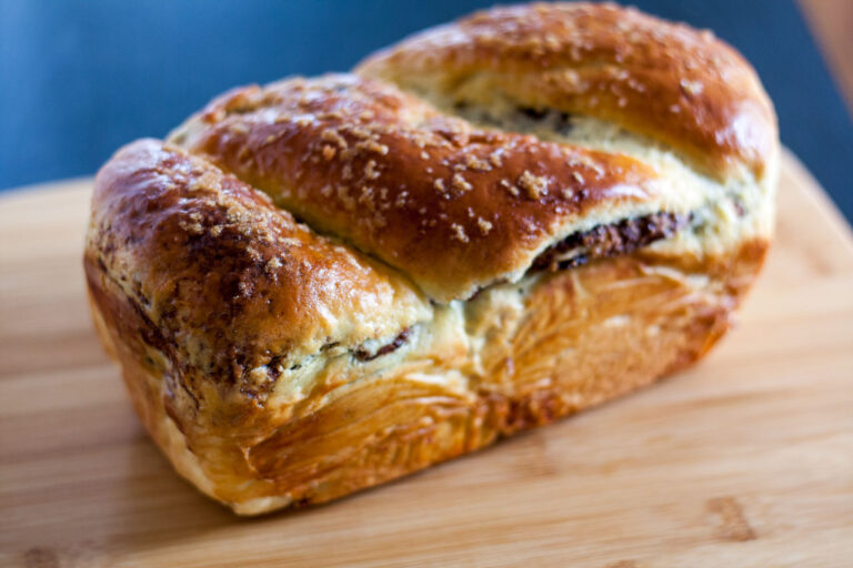 Whole loaf of cozonac bread on a cutting board,