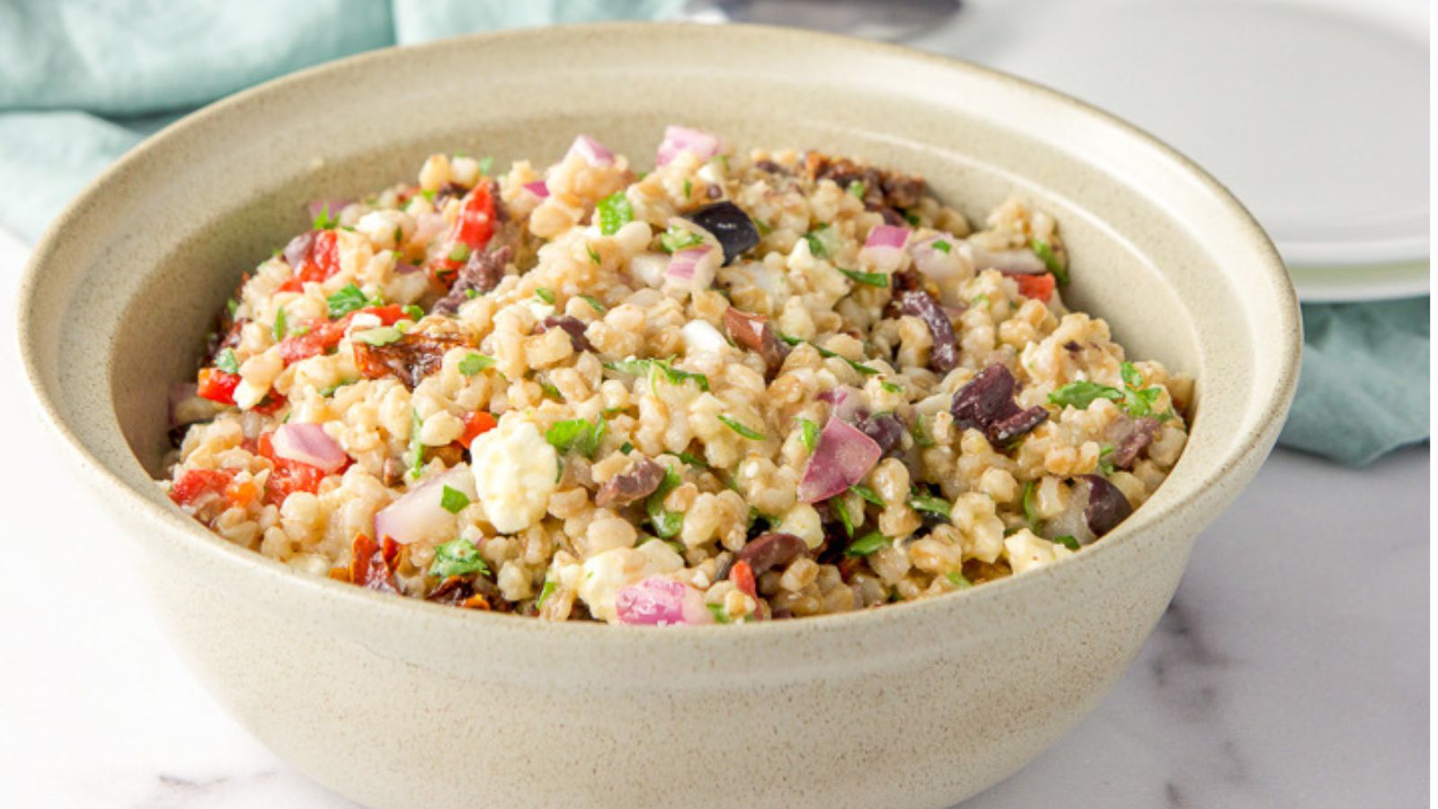 Farro salad in a beige bowl.