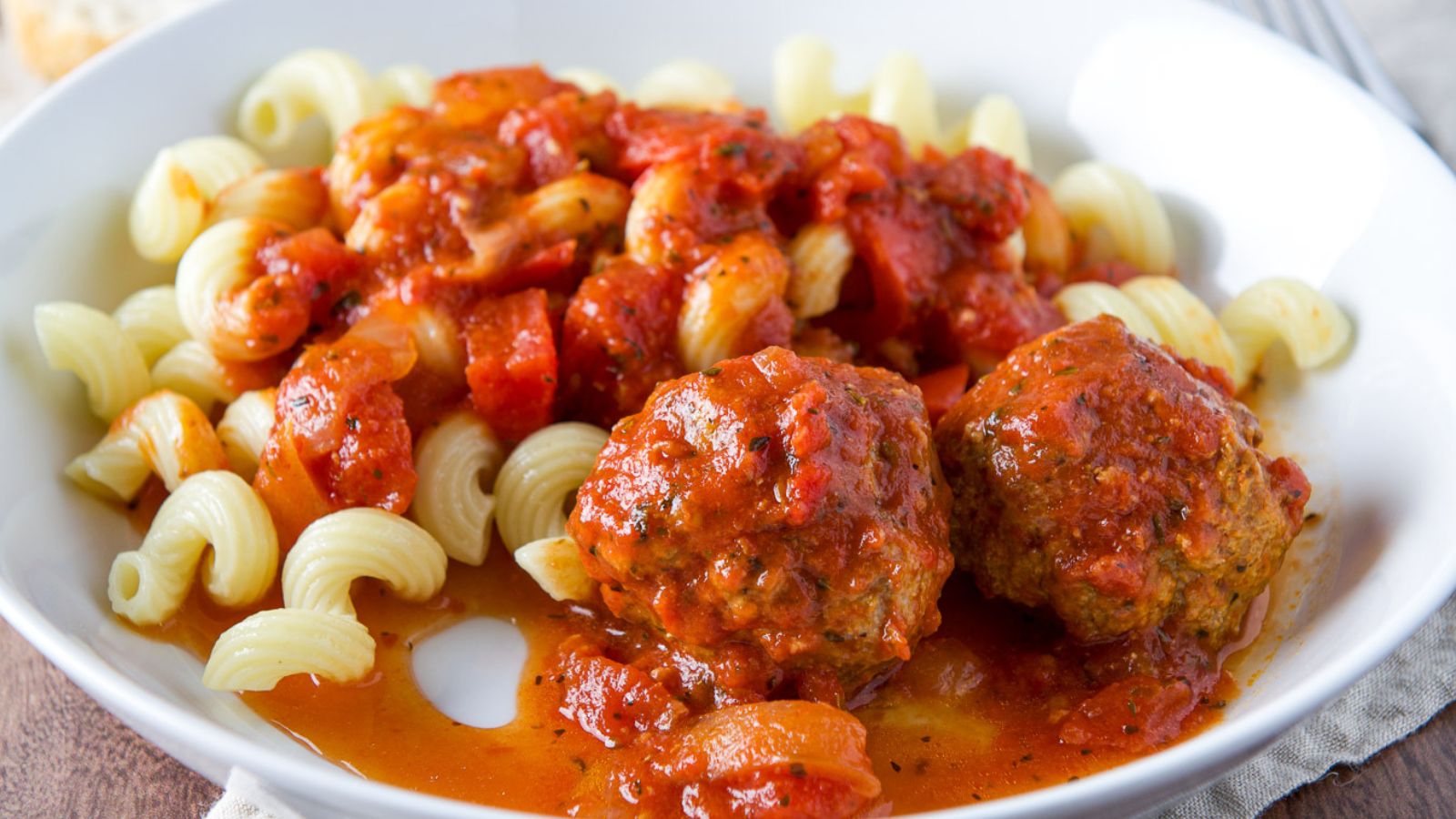 Meatballs and sauce on pasta.