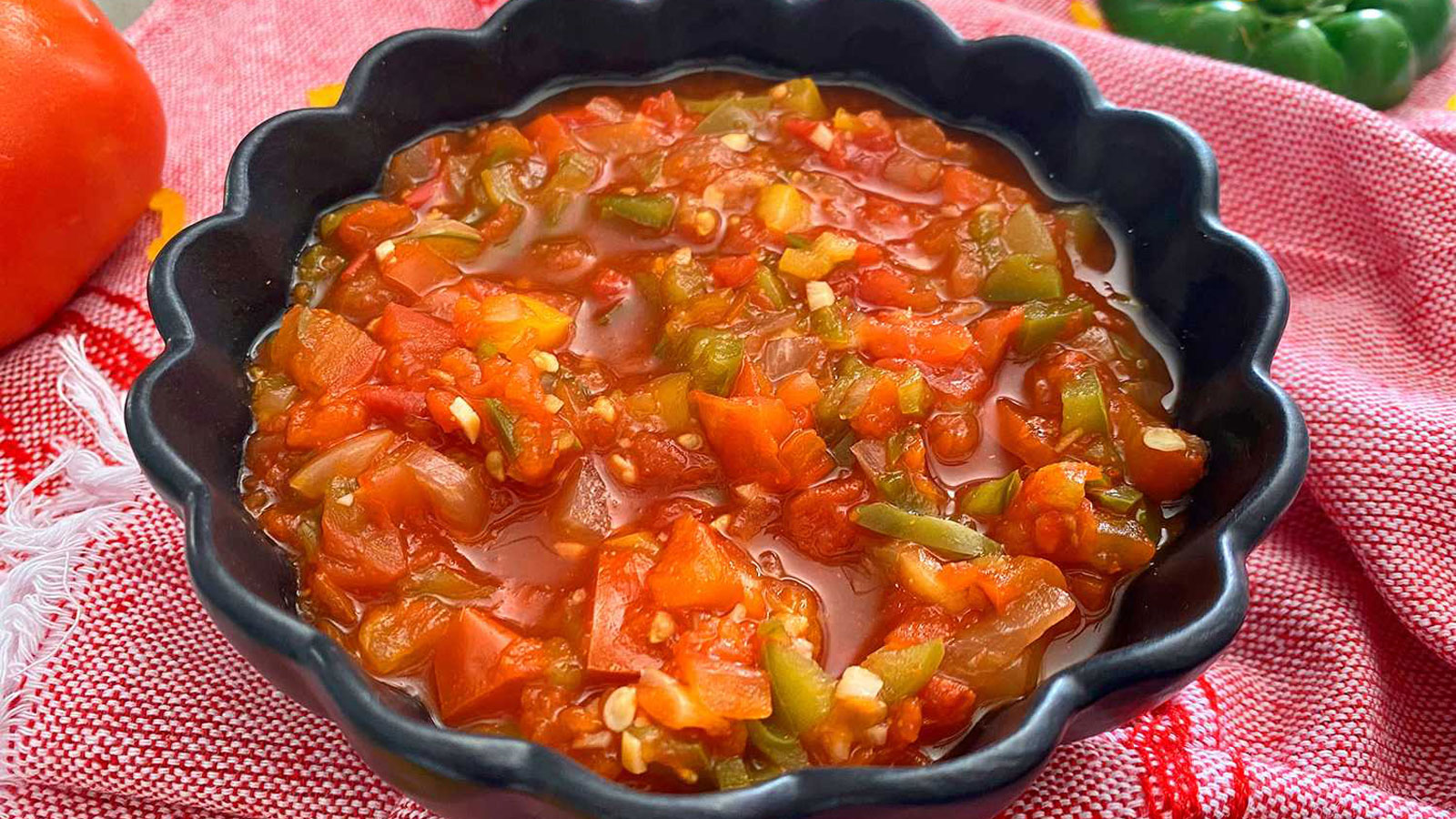 Black bowl filled with tomato salsa.