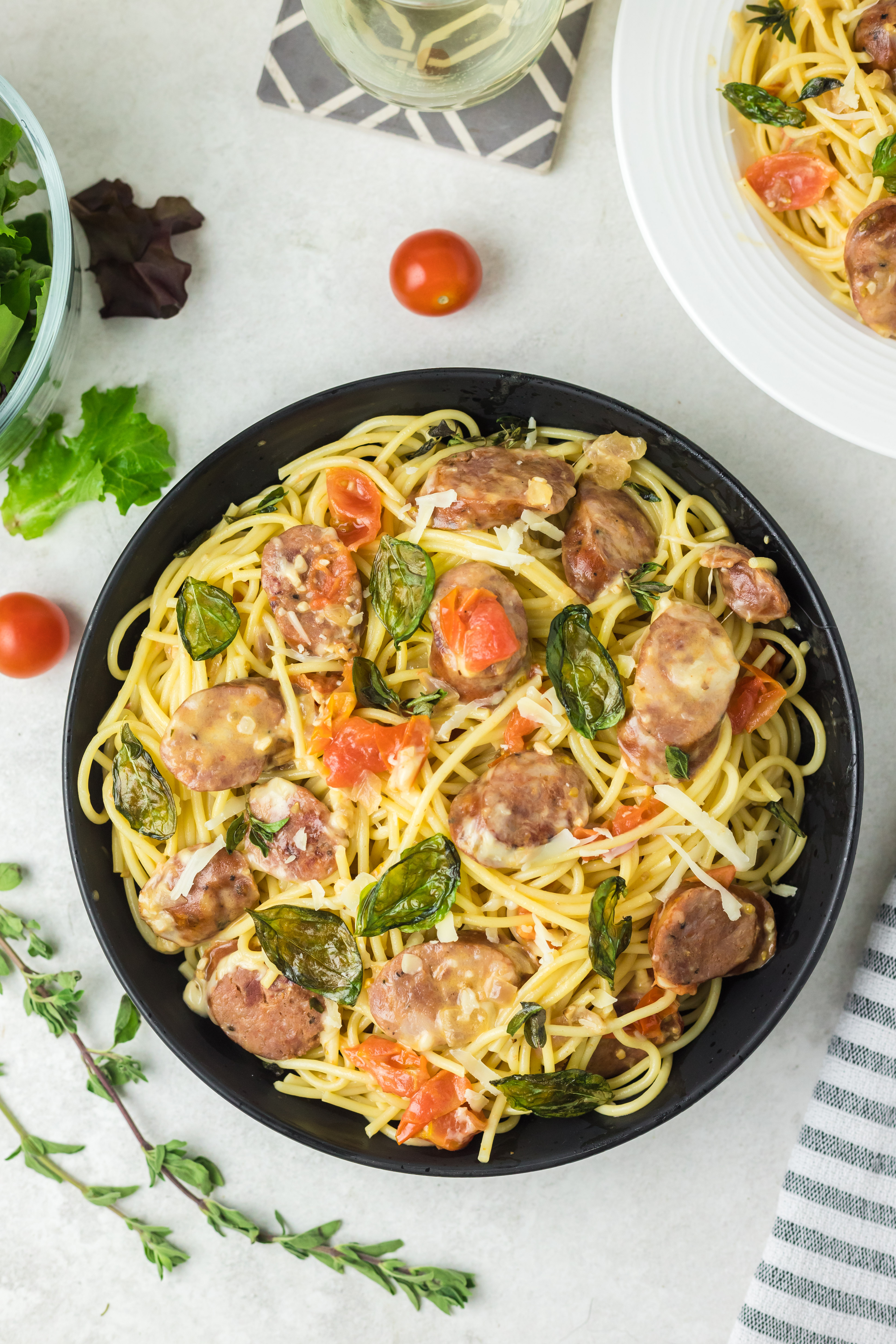 Black bowl filled with chorizo pasta on a white background.