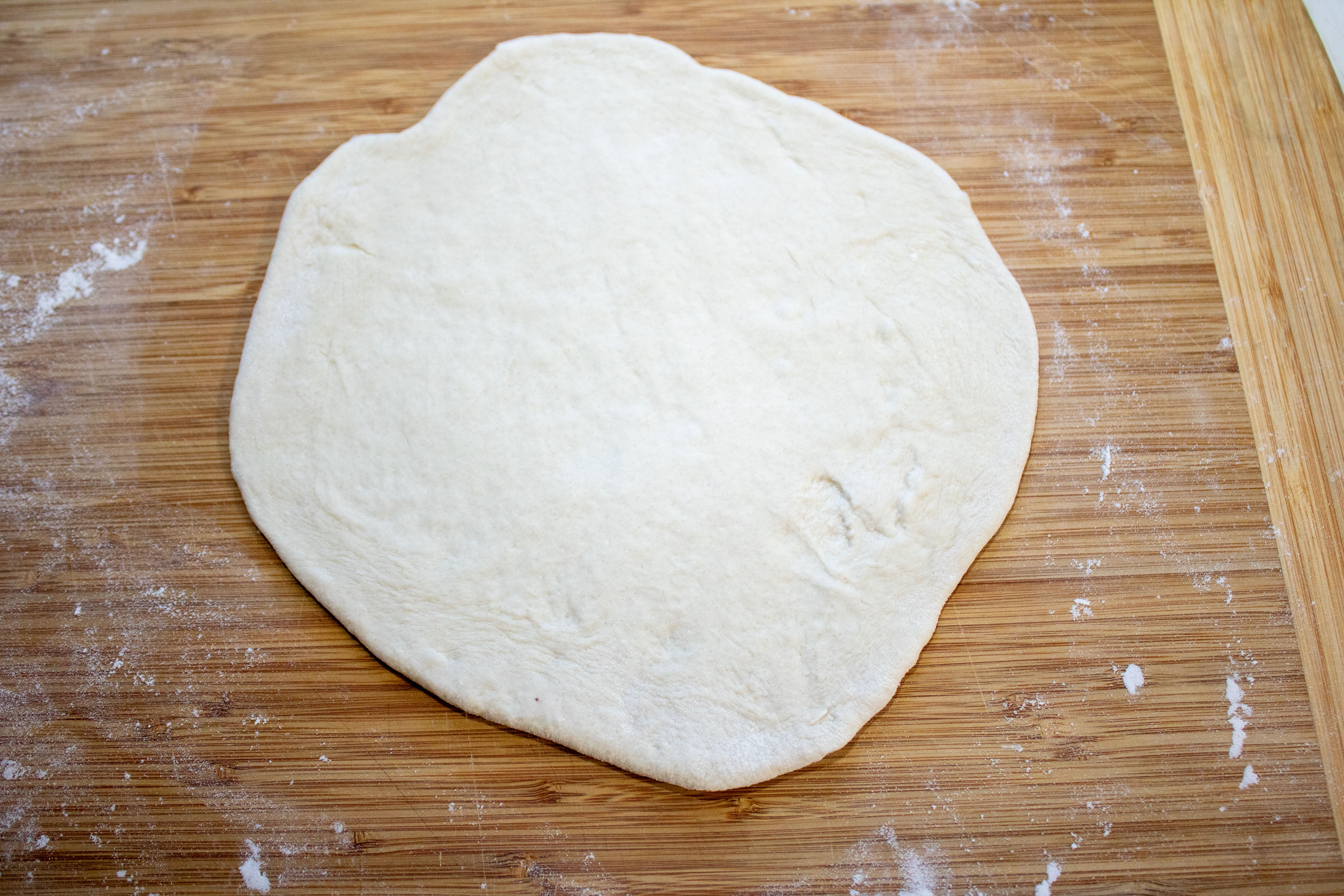 Dough rolled out on a wooden board.