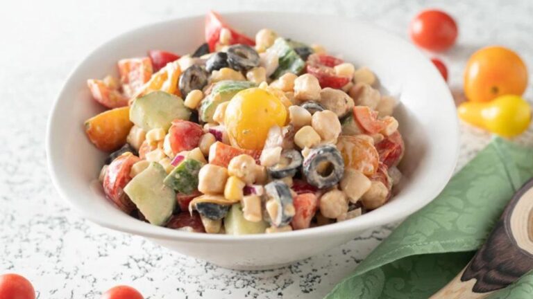 Colorful chickpea salad in a white bowl.